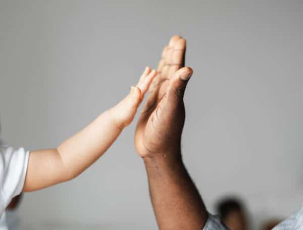 adult and baby high fiving