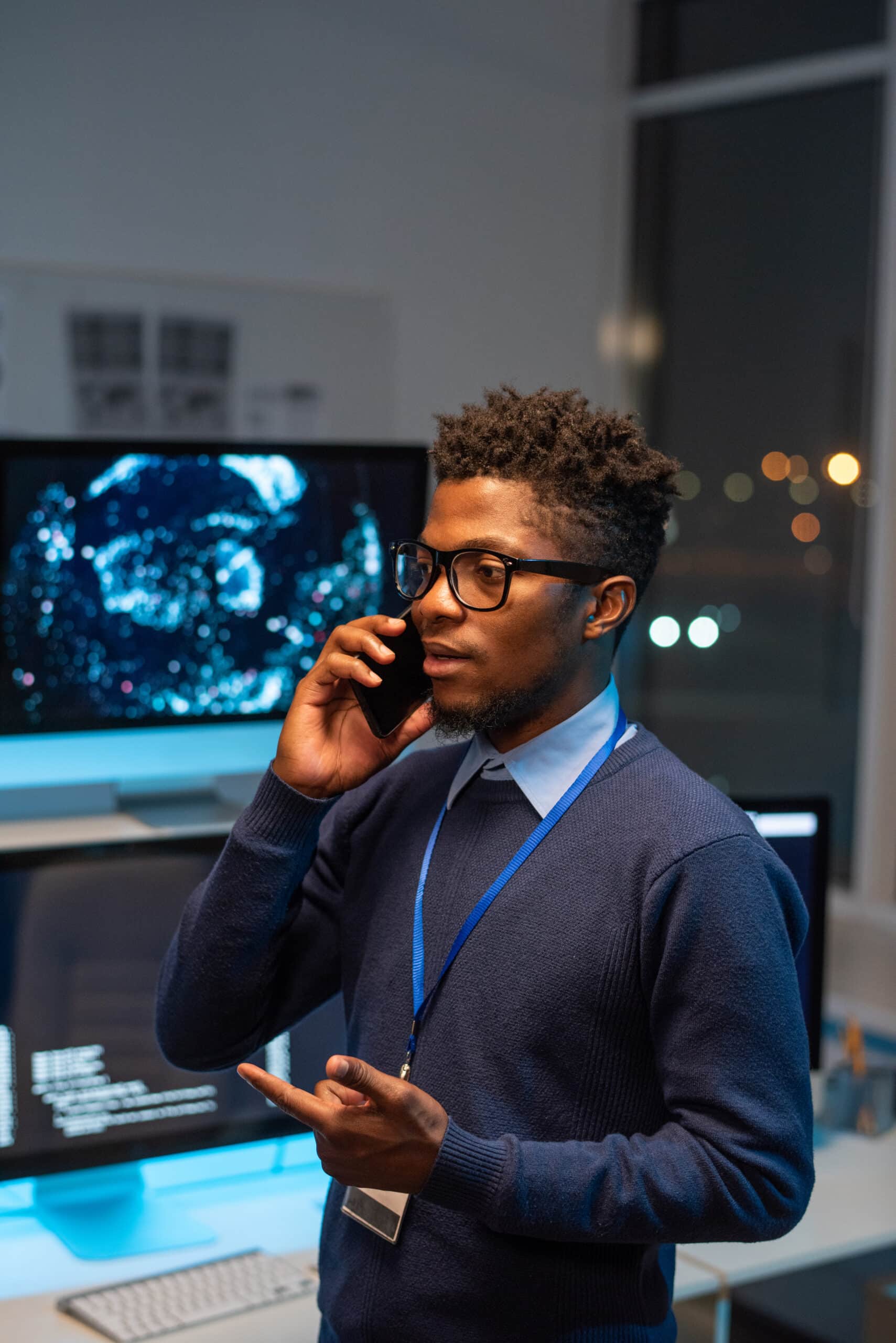 Young well-dressed programmer communicating on smartphone