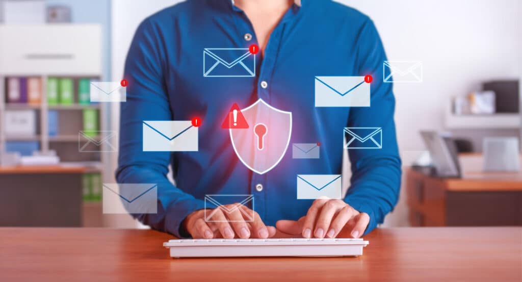 A man with digital email symbols hovering over his keyboard